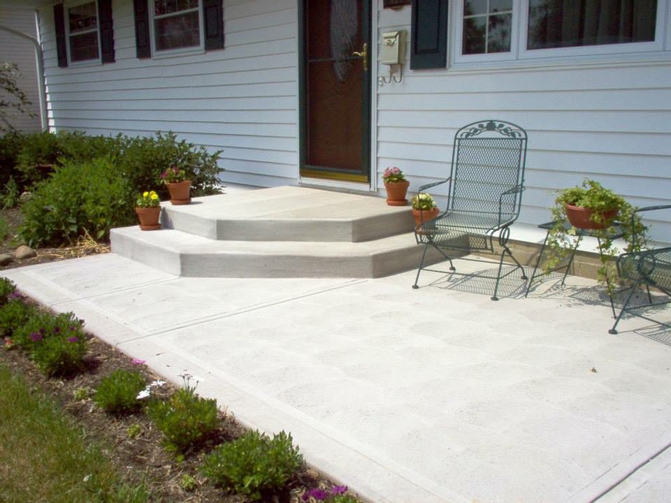 A patio with steps leading to the front door.